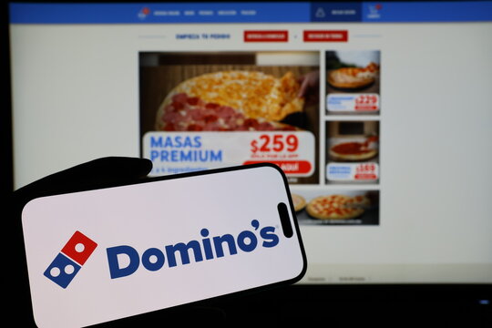 Kiel, Germany - 03-06-2026: Smartphone displaying US pizza restaurant company Dominos Pizza logo in front of companys webpage