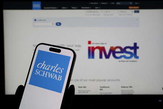 Kiel, Germany - 03-06-2026: Smartphone displaying US financial services company Charles Schwab logo in front of companys webpage