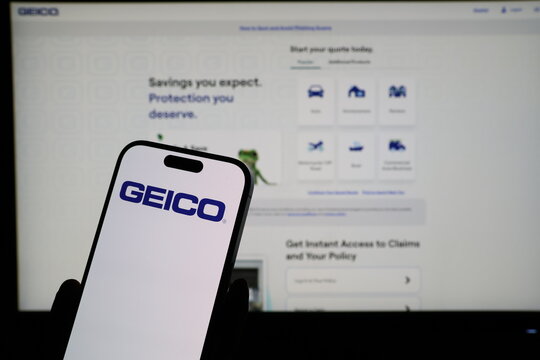 Kiel, Germany - 03-06-2026: Smartphone displaying US insurance company Geico logo in front of companys webpage