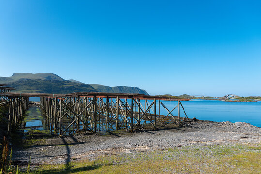 Traditional stockfish racks near Fredvang, with the Fredvang Bridges in the background.. Lofoten in Norway.