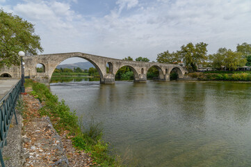 Fototapeta premium Bridge of Arta Seen along the Riverbank, Greece