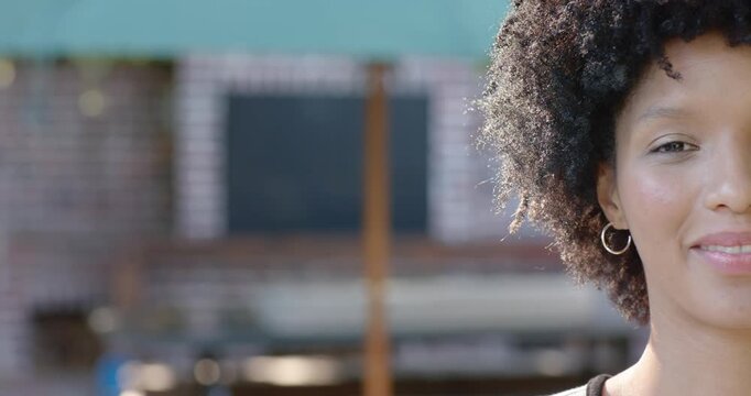 African American woman smiling then laughing after off-camera cue by brick wall hoop, copy space