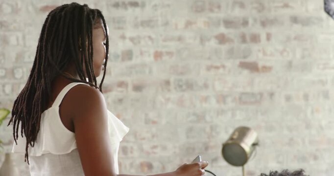 African American women friends calling, showing smartphone for selfie and hugging near softbox