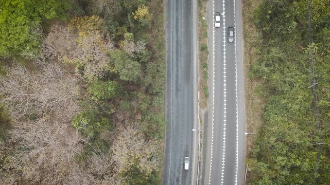 Drone aerial view of rural farmland with country road crossing agricultural fields. Countryside landscape showing agriculture