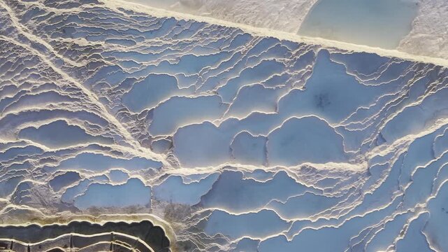 Cinematic aerial drone video of Pamukkale travertines and thermal pools in Denizli, Turkey, highlighting the white calcium terraces, natural formations, and panoramic scenic landscape from above.
