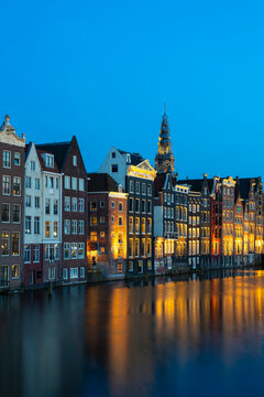Dancing houses near tower of Oude Kerk Amsterdam Church at twilight, Damrak, Amsterdam, Netherlands