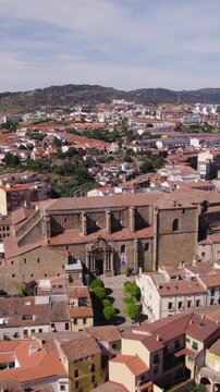 Vertical aerial orbit capturing the historic Palacio de Mirabel and surrounding skyline in Plasencia, Spain.