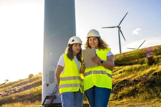 Engineers checking wind turbine plans, working for sustainable energy solutions