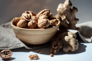 Obraz premium Walnuts in a wooden bowl with Ginger Still-Life