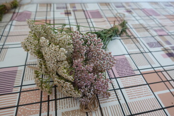 Dried yarrow flower bouquets on patterned tablecloth © tonifrito