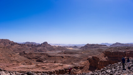 Tibesti Mountains, in the central Sahara of the extreme north of Chad. Tibesti is often called the roof of the Sahara, one of the most remote and least visited locations. Two persons enjoying the view