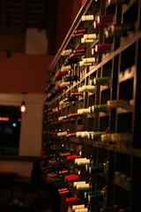 Estante de madera con botellas de vino tinto en bodega o vinoteca