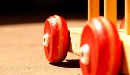 Primer plano de ruedas rojas de madera de un juguete artesanal con enfoque selectivo