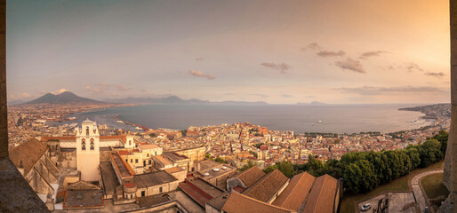 Obraz premium Golden sunset over Naples and the Bay of Naples seen from Castel Sant'Elmo, with Mount Vesuvius rising above the Mediterranean coast, Campania, Italy