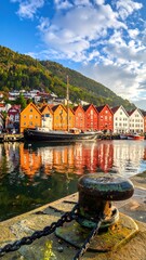 Fototapeta premium Colorful waterfront buildings reflect in calm water under a blue sky