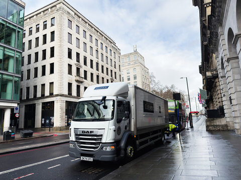 London street scene with a large delivery clean services truck beside historic buildings on a rainy day. A L Cleaners London.