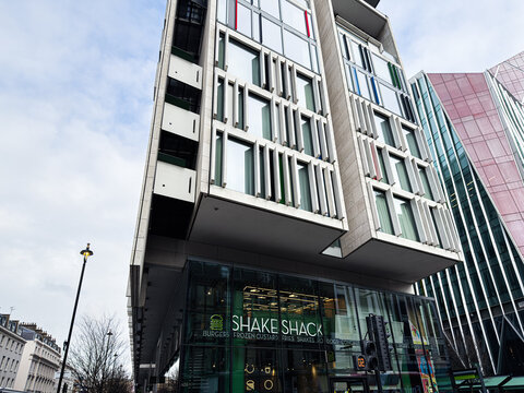 Modern London Shake Shack occupies striking glass storefront in contemporary urban building near city center