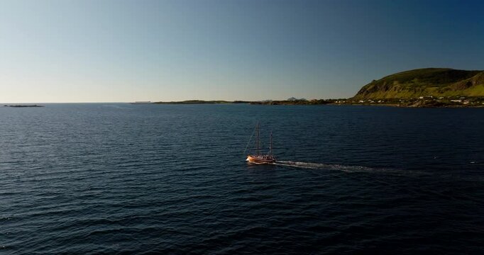 Vintage Boat Navigating Deep Blue Waters Of The Lofoten Islands Near Hadsel Municipality, Norway. Aerial Shot