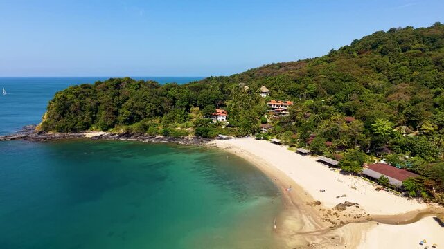 Drone video capturing the pristine Khlong Chak Beach on Koh Lanta, Thailand. Crystal clear waters, vibrant greenery, and soft sandy shores create a tranquil tropical paradise from above.