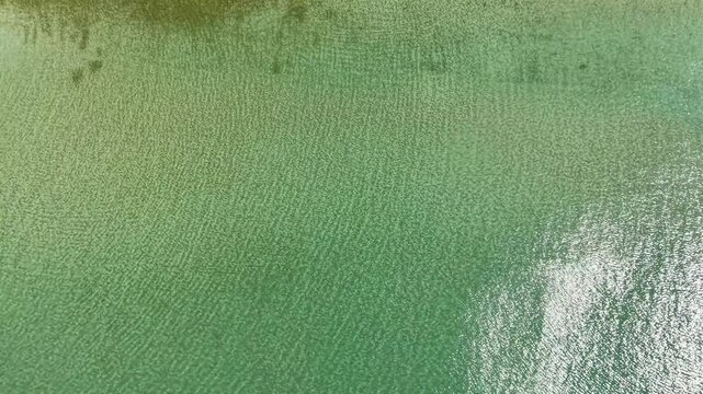 Aerial footage captures the serene, untouched beauty of Khlong Chak Beach on Koh Lanta Island. Experience the tranquil mood and clear, emerald waters from above.