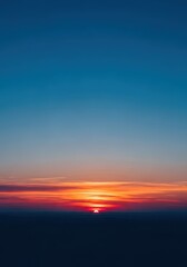 Obraz premium The deep blue sky transitions to soft orange and pink light as the sun disappears below the horizon, bathing the landscape in cool, tranquil tones, morning, celestial, natural