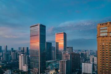 Fototapeta premium Modern skyscrapers reflecting sunrise glow in Chengdu cityscape