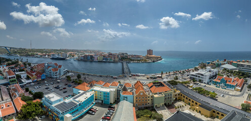 Obraz premium Aerial View of Willemstad, Curaçao: Iconic UNESCO World Heritage Site, Colorful Handelskade Waterfront, Queen Emma Bridge and Historic Dutch Architecture