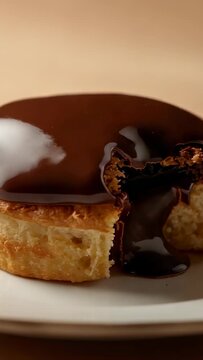 Vertical video: Drizzling warm chocolate offscreen over table, sauce filling pastry core to glaze