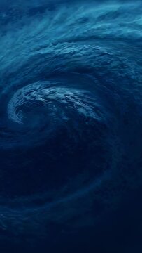 Vertical video: Rotating dark blue vortex pulling water inward via surface flow at sea with foam