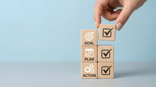 Hand stacking wooden blocks with goal, plan, action checklist and checkmarks