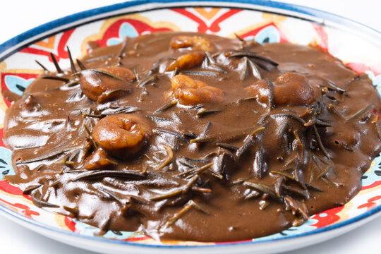 Mexican romeritos with mole sauce and shrimp isolated on white background. Close up