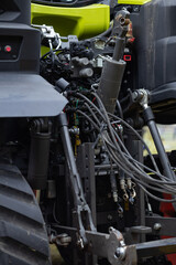 Fototapeta premium Detailed view of heavy duty three point hitch and hydraulic connections on a modern tractor for mounting farm implements. Preparation for spring field work and soil cultivation
