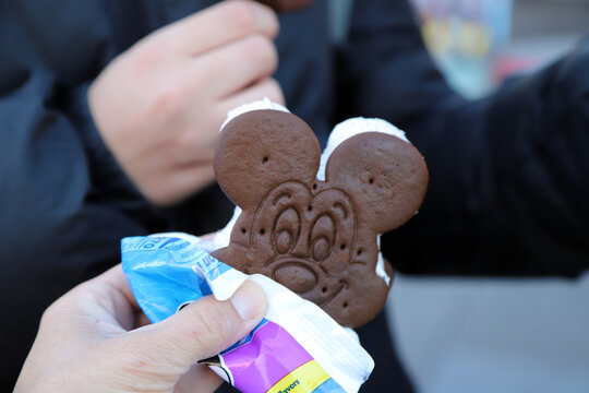 Person eating a Mickey Mouse Ice Cream Sandwich Snack 