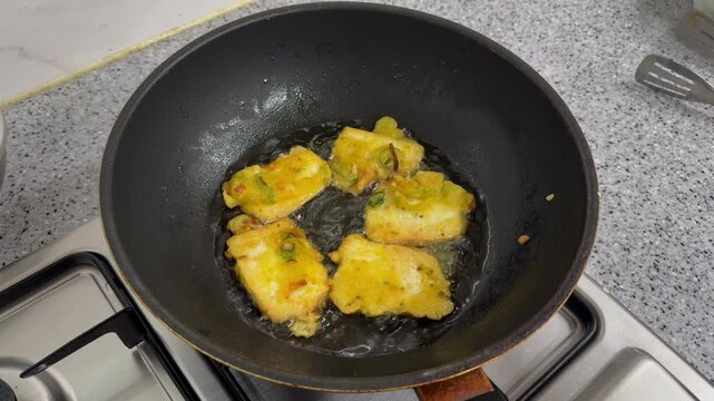 Indonesian traditional food Tahu Goreng or Fried Tofu.Cubes Deep Frying in Hot Oil with Bubbling Texture Close Up