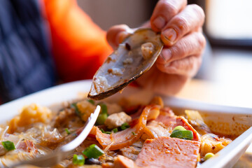 Person eating spicy mussel, authentic Asian meal and vegetables local bistro, oriental cuisine, lunch restaurant, delicious food and dining process, savoring fresh ingredients in professional kitchen