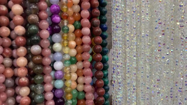 Multicolor children's necklaces and bead bracelets on a shop display. Bright jewelry with plastic flowers and figures, concept of kids fashion, gifts, and accessories for girls.