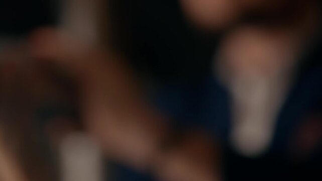 Close-up of hands shaking cocktail in dark bar. Bright lights glow behind. Person focused, calm, precise. Perfect for nightlife, drink ads, or party scenes. No animals or plants shown