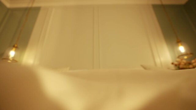 Soft, warm light glows from bedside lamps. White sheets and pillows fill the frame. Serene, restful mood suggests comfort and calm. Ideal for sleep, relaxation, or luxury bedroom scenes