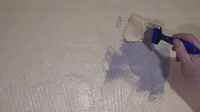 Closeup Of Hand Smoothing Paint Edge. Indoor Scene Showing Detailed Wall Patch And Texture Blending