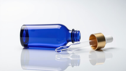 Blue glass dropper bottle with gold cap and pipette on white background, reflecting minimalistic style for skincare or cosmetic product concept
