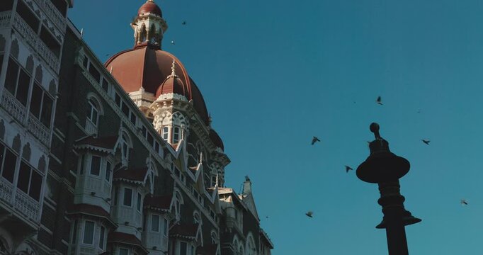 Mumbai, India. Close-up View On Taj Mahal Palace Is Heritage, Five-star, Luxury Hotel In Colaba Area Of Mumbai Situated Next To Gateway Of India. Blue Clear Sky In Sunny Day With Fly Birds In Slow