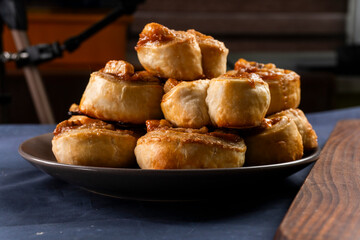 Freshly baked banana caramel puff pastry rolls on a baking sheet. Pastry. Dessert © Denis
