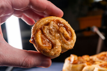 Freshly baked banana caramel puff pastry rolls on a baking sheet. Pastry. Dessert © Denis