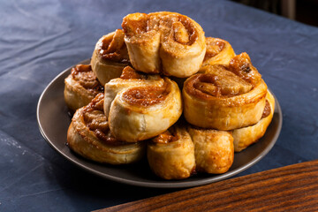 Freshly baked banana caramel puff pastry rolls on a baking sheet. Pastry. Dessert © Denis