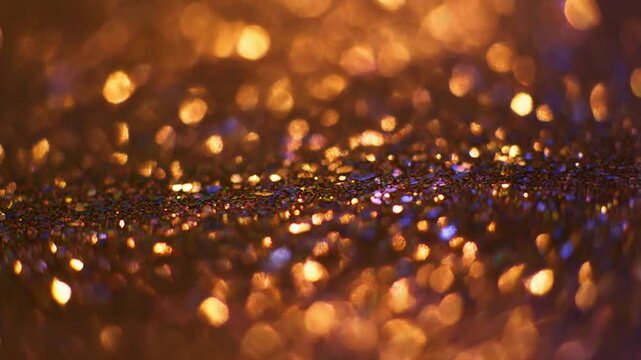 Sparkling glittering sequins scattered densely across a dark background, viewed from directly above, capturing a festive atmosphere