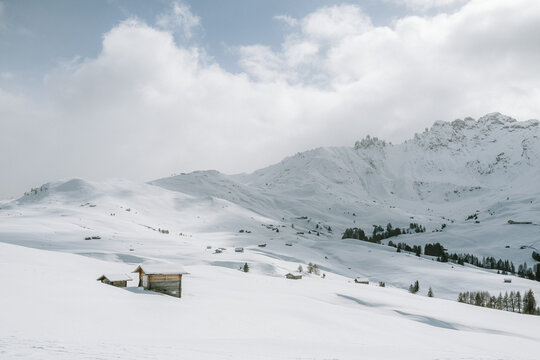 verschneite Landschaft mit Holzh&uuml;tten auf der Seiser Alm