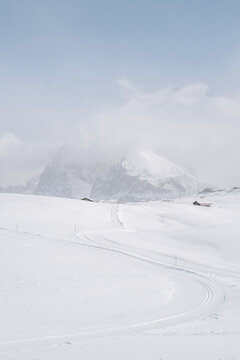 Blick von der Seiser Alm auf das Langkofelmassiv im Winter mit Skipisten und Langlaufloipen