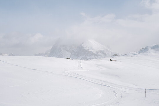 Blick von der Seiser Alm auf das Langkofelmassiv im Winter mit Skipisten und Langlaufloipen