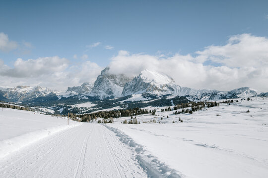 Blick von der Seiser Alm auf das Langkofelmassiv im Winter mit Skipisten und Langlaufloipen