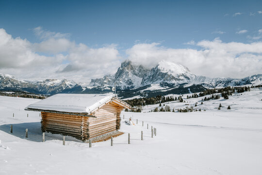 Blick von der Seiser Alm auf das Langkofelmassiv im Winter mit H&uuml;tten, Skipisten und Langlaufloipen im Vordergrund